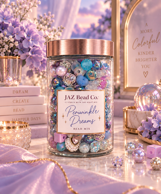 JAZ Bead Co. Periwinkle Dreams bead mix in a clear jar, featuring dreamy periwinkle, lavender and blue beads with iridescent, pearl and sparkling accents in a soft floral setting.