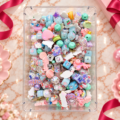 Overhead view of JAZ Bead Co. Mega Mix in a clear tray with colorful character-inspired beads, pastel aqua and pink cubes, novelty shapes, bows, hearts, sweet-treat pieces and transparent accents.