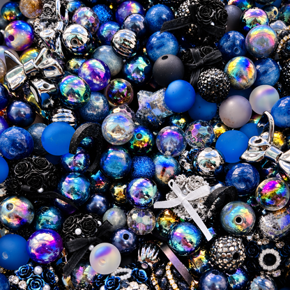 Midnight Moonlight bead mix spilling from a clear jar, revealing deep blue, black, silver and iridescent beads with crescent moons, stars, floral focals and sparkling accents.