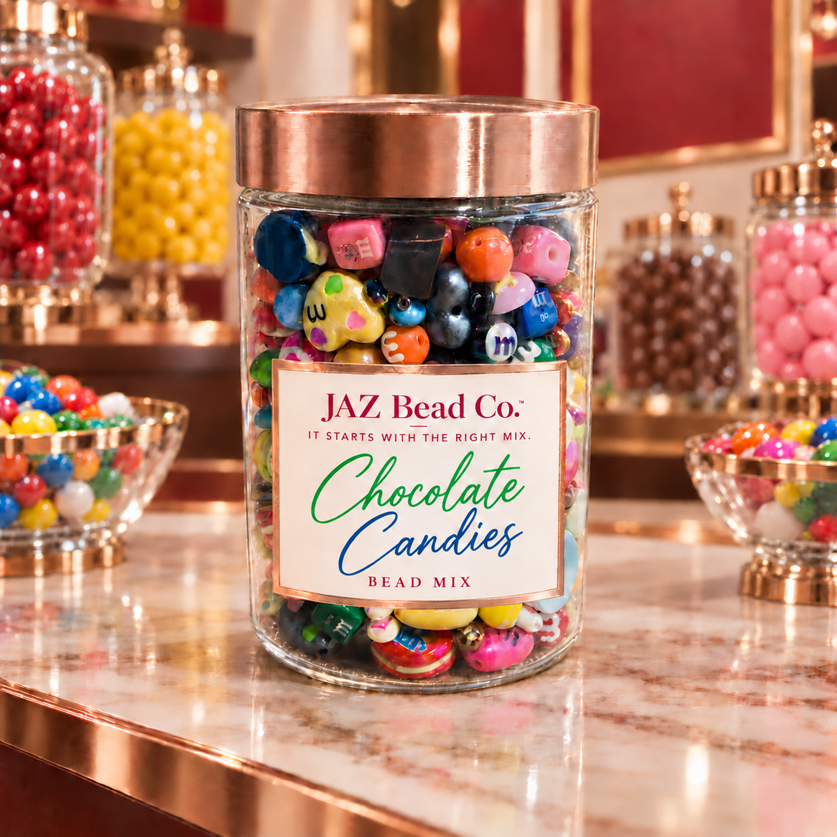 Clear JAZ Bead Co. jar labeled Chocolate Candies with a rose-gold lid, filled with colorful candy-inspired beads in pink, blue, green, yellow, orange, red, purple and brown, displayed on a candy-shop counter with glass candy jars in the background.